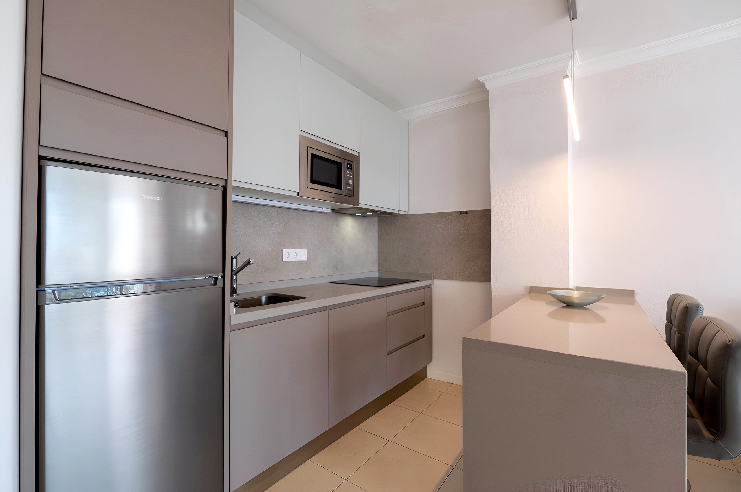 Kitchen with fridge and dining counter